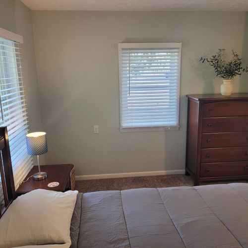 Bedroom #1:  features a queen-size bed, private en suite full bathroom, private television, walk-in closet, dresser, mirror, nightstands, and lamps