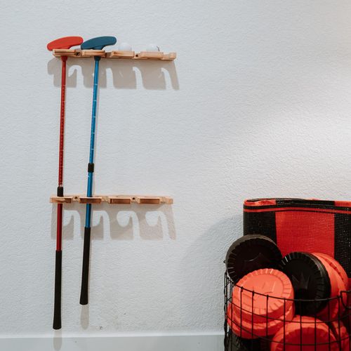 - wall mounted putters and golf balls for easy grab and play entertainment
- basket of oversized checkers adds a twist of family friendly competition
- perfect corner setup to keep all ages active and engaged indoors