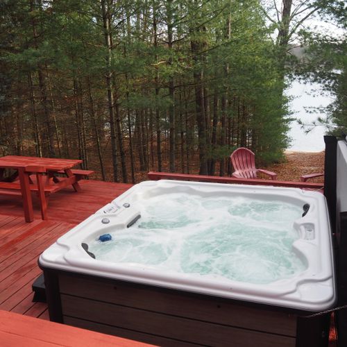 Exterior:  another view of the new year-round hot tub / spa and the huge deck, highlighting the picnic table and the lake in the background.