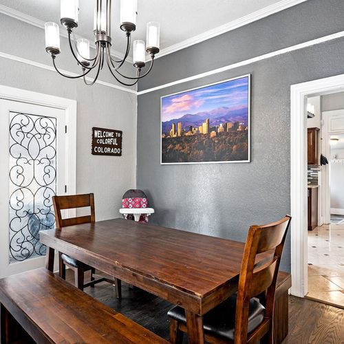 - wood dining table with bench seating provides room for group meals or board games
- chandelier lighting and a colorado skyline print set a cozy and welcoming tone
- just off the kitchen, this space invites connection and shared memories