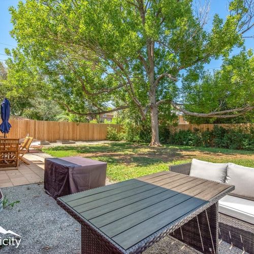 - spacious fenced backyard with both a shaded dining set and chill out seating
- mature trees, privacy fencing, and green grass set the scene for outdoor fun
- dine under the umbrella or relax at the patio sofa with your morning coffee