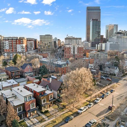 Lively city setting with classic architecture, green streets, and modern skyline views