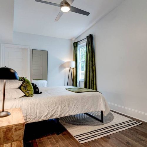 Stylish third bedroom w/ a queen bed, bold accents & warm lighting.