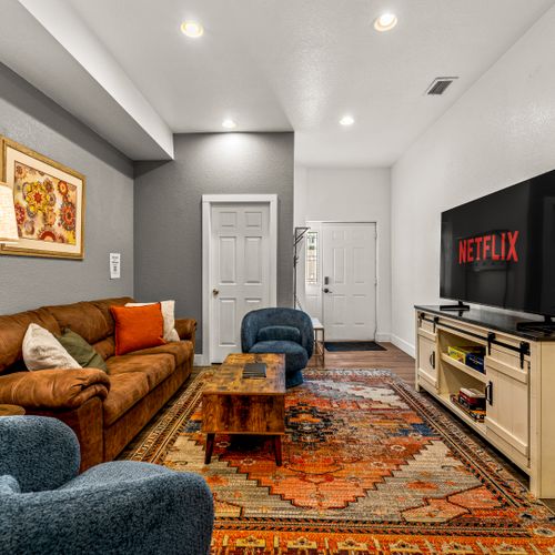 The restful living space holds a large sectional, charming decor and smart tv with netflix.