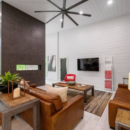 The open-concept living room with luxury couches situated around the tcv.