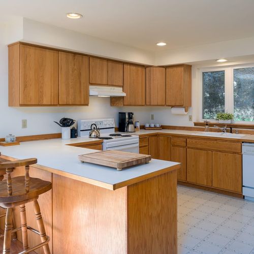 Spacious kitchen with counter seating and garden views.