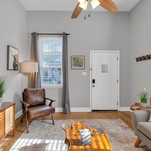 Welcoming entryway w/ a leather chair & soft tones — a relaxed first impression.