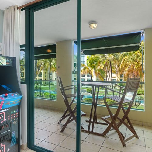 Step out to the breezy balcony with direct views of the serene community pool and lush tropical gardens.