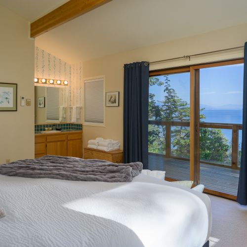 The main bedroom with a king bed and private deck outside.