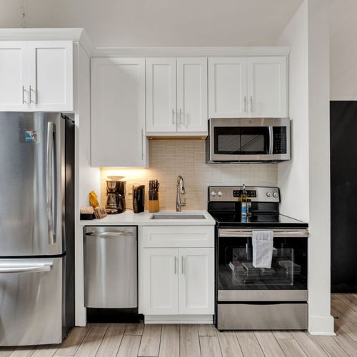 Fully equipped kitchen w/ stainless steel appliances, coffee station & sleek finishes.