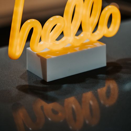 Feel instantly at home as the warm glow of the 'hello' sign greets you upon entry, enveloping the space in a cozy and welcoming ambiance.