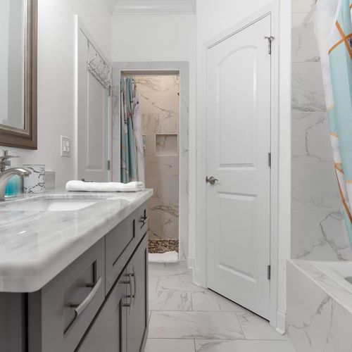 Light & airy bathroom w/ shower & colorful curtain detail.