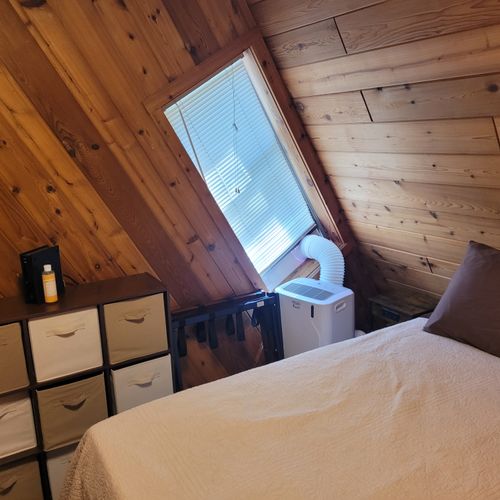 Bedroom #2 (main floor):  features a queen-size bed, portable a/c unit, closet, and drawers.