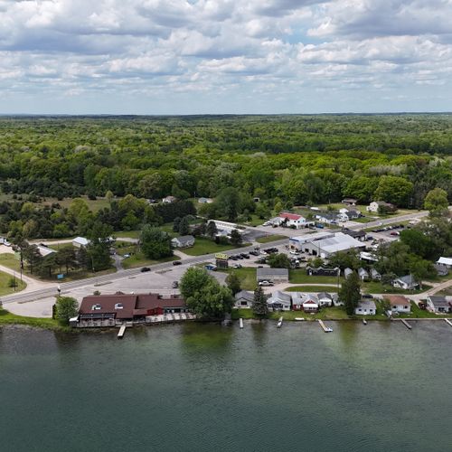 Overall:  a drone shot of the lake with the house in the background and the turk lake restaurant and bar just to the left of it