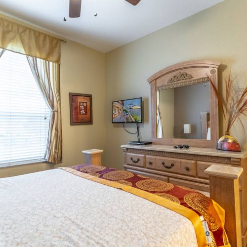 Downstairs master bedroom includes luxurious bed, plenty of drawer space