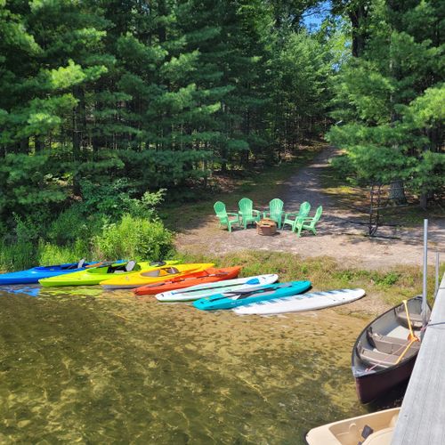 Exterior:  another view of the private lakefront showing the dock, pedal boat, canoe, kayaks, paddleboats, and bonfire ring.