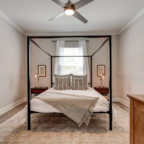 Master bedroom w/ a canopy bed & en suite bathroom for a private retreat feel.