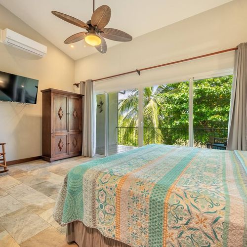 You will find the master BDR on the second level. It has a king size bed, a flat TV screen and balcony to enjoy the sound of the waves and the tropical vegetation.