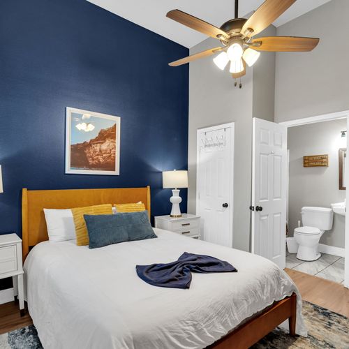 Bright white bedroom w/ a plush bed & clean, airy feel — rest easy here.