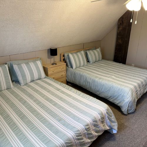 Bedroom #3 (upstairs):  features two queen beds, a ceiling fan, a nightstand, a lamp, and 2 large closets.