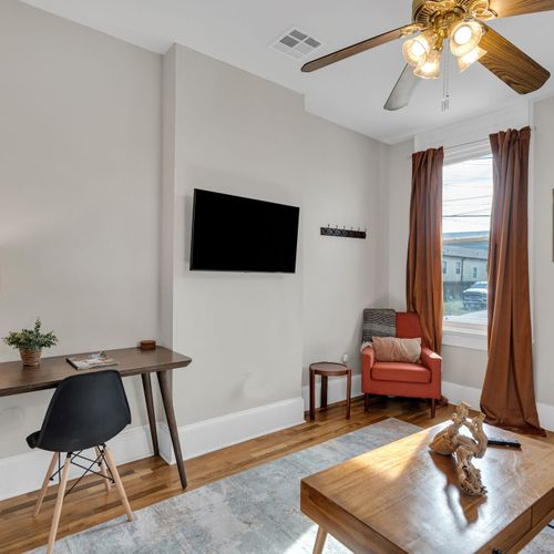 Relaxed living area w/ wall-mounted TV & a small workspace for when you need to plug in.