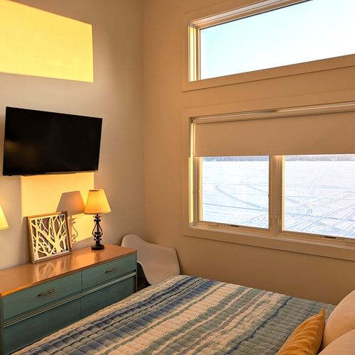 BEDROOM #3 (UPPER LEVEL):  Gorgeous top floor (third floor) bedroom with a king-size bed, nightstands, nightlamps, private television, dresser. closet, amazing view of Crystal Lake, and private entrance to the top floor bathroom!