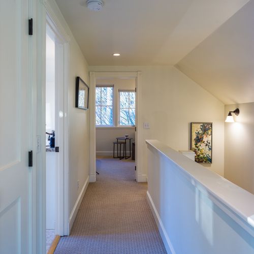 An open upstairs landing with artwork and soft lighting that adds character and flow.