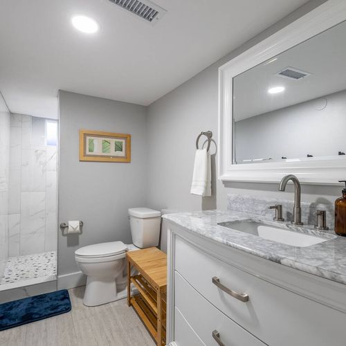 - enjoy a roomy shower with mosaic stone flooring and bright tile surround
- polished marble countertop and wide mirror offer style and function in one
- natural textures and warm lighting create a calming, well equipped retreat