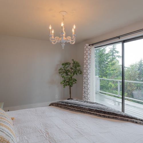 Master bedroom overlooking the deck outside with water views.
