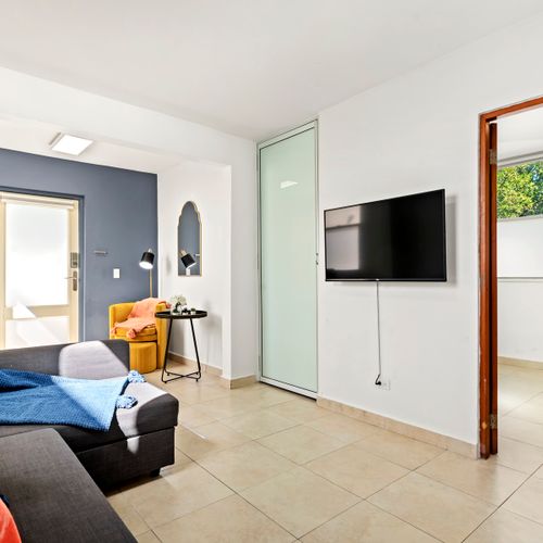 Kick back and watch your favorite shows. The living room features a large smart TV and stylish decor for ultimate relaxation and entertainment.