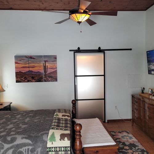 Bedroom #2 (second floor):  very large bedroom features a queen-size bed, walk-out deck, chair, 2 nightstands, 2 lamps, 2 dressers, ceiling fan, television, and private en suite full bathroom