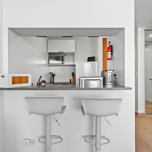 Sleek and modern, our kitchen bar setup is perfect for a quick breakfast or evening cocktails. Enjoy the convenience of modern appliances and stylish seating in a compact, efficient space.