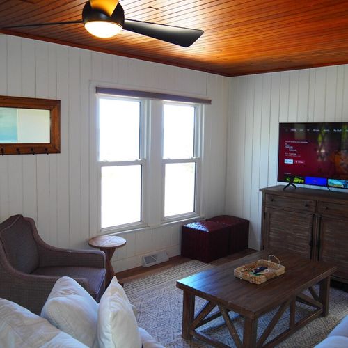 Living room:  the home has a very comfy living room with all new furniture, a ceiling fan, great views of crystal lake, a game table, and a wood-burning fireplace!