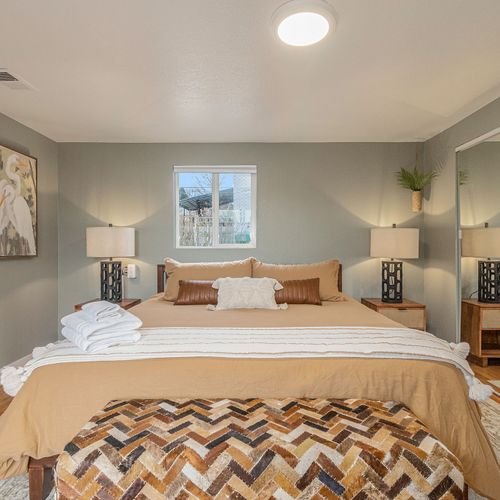 - matching nightstands and lamps bring symmetry and calm to this restful space
- soft neutrals, cozy throws, and a patterned bench add charm and comfort
- enjoy a peaceful stay in a thoughtfully styled bedroom with restful tones