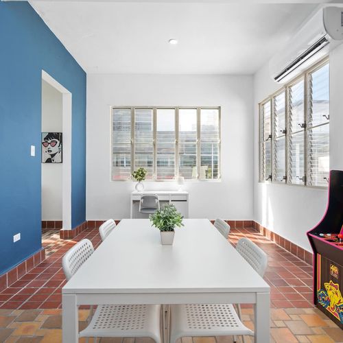 Discover the perfect room for leisure or work, featuring a unique addition: an arcade machine.
