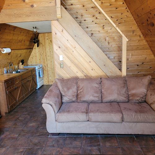 Living room:  features a sofa, futon, and a large television with cable television.