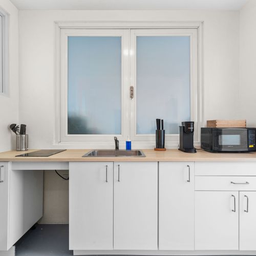 Streamlined kitchenette with modern appliances, providing all you need to whip up a quick meal or a hot cup of coffee before exploring.