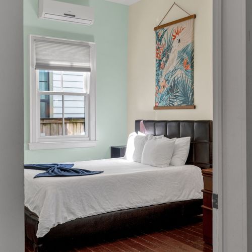 Bright bedroom w/ soft linens & peaceful natural light streaming in.