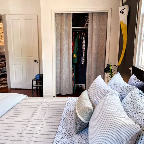 Well-lit exterior entrance w/ a bold yellow door, perfect for evening arrivals.