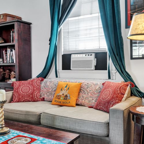 Comfy sofa piled w/ colorful pillows — made for relaxing evenings.