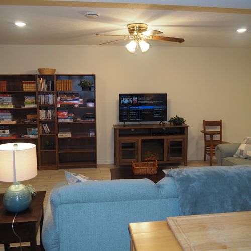 Living room:  the apartment has a very comfortable living room with a sleeper sofa, comfy chair, ceiling fan, table, and television.