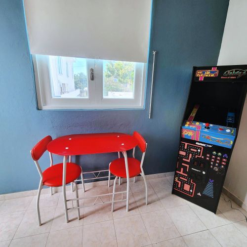 Savor your meals and enjoy pleasant conversations in this comfortable and inviting dining area. The vibrant red chairs add a touch of warmth, making it the perfect spot for memorable moments.