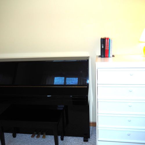 Office (main floor):  features a comfy chair, piano, dresser, and desk with chair.