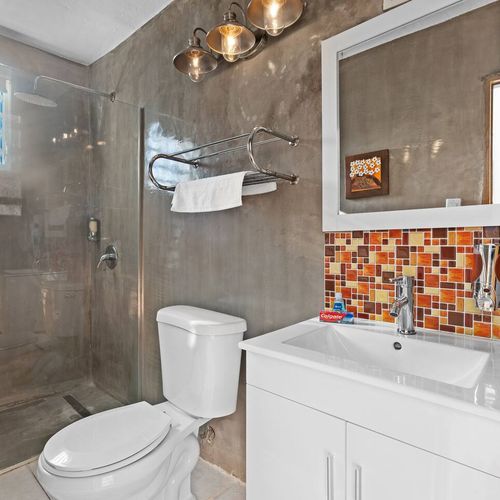 Find comfort in a well-illuminated bathroom furnished with modern fixtures and a generous shower space.
