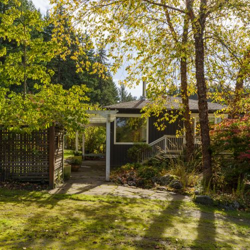 Arrive through a peaceful garden path framed by mature trees—an inviting first impression that sets the tone for a quiet, nature-filled stay.