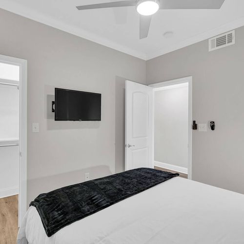 Comfortable bedroom w/ a wall-mounted TV for easy late-night streaming.