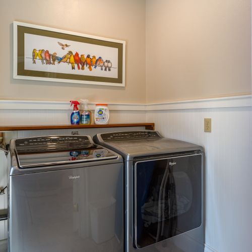 Laundry room has large capacity washer and dryer plus a utility sink.
