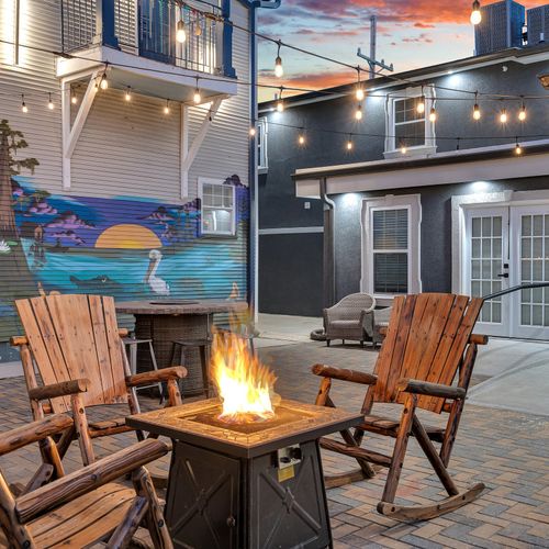 Gather around the fire pit for cozy nights under the string lights and a colorful mural backdrop.