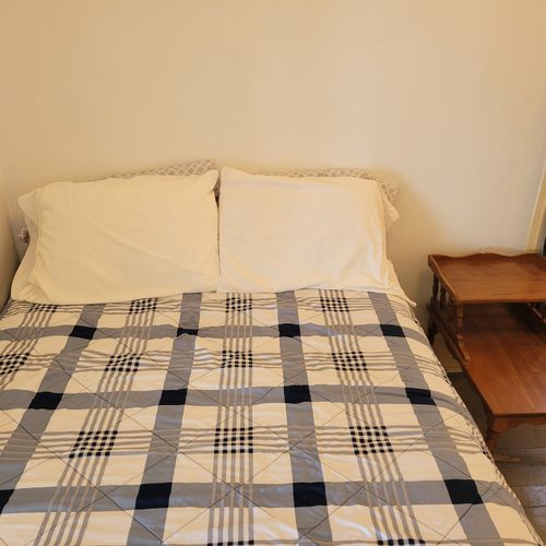 BEDROOM #2 (MAIN FLOOR):  Features a full-size bed, nightstand, chair, dresser, mirror, and closet.