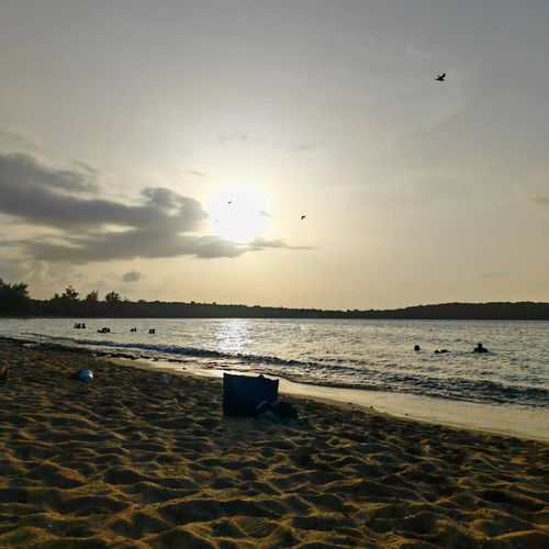 Golden hour bliss on the beach! Enjoy a serene sunset over tranquil waters with gentle waves and a peaceful ambiance.
